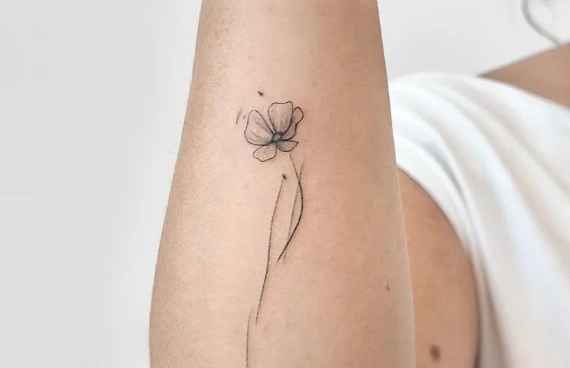 님의 여성 팔뚝에 새겨진 섬세한 라인워크 양귀비 문신