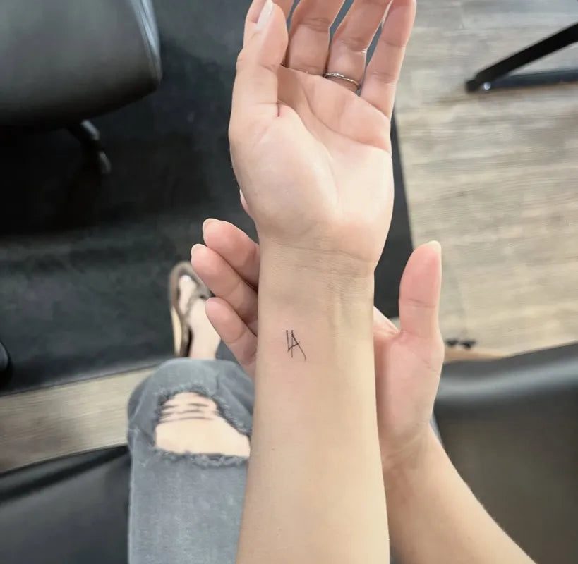 여성 손목에 새겨진 작고 미니멀한 알파벳 A 타투