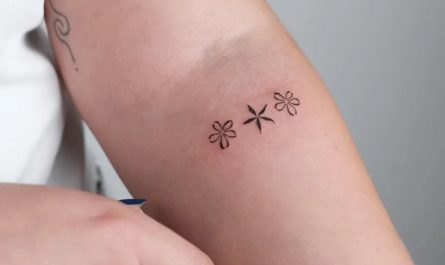 여성 팔에 작고 미니멀한 세 송이 데이지 문신