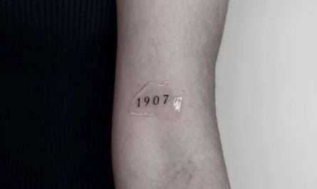 여성 팔에 새겨진 작고 미니멀한 1907 숫자 문신