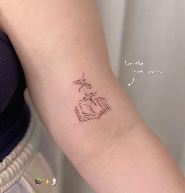 여성 팔에 작은 선으로 그린 ​​책과 새 문신