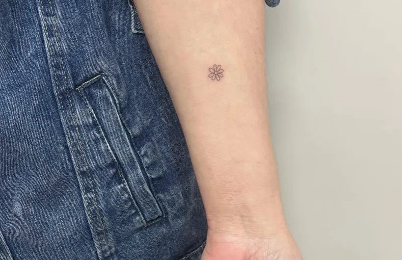여성 팔에 있는 작고 미니멀한 점 문신
