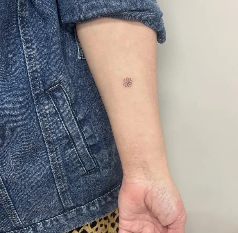 여성 팔에 있는 작고 미니멀한 점 문신