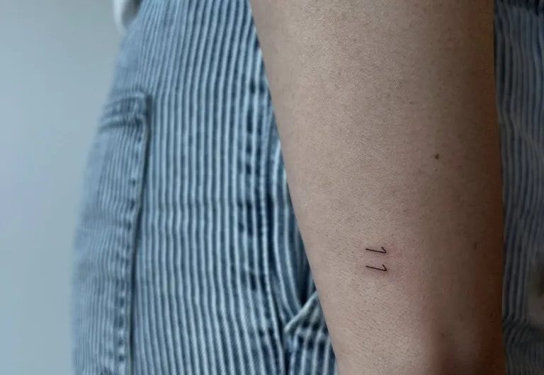 여성 손목에 새겨진 작고 미니멀한 두 개의 평행선 문신