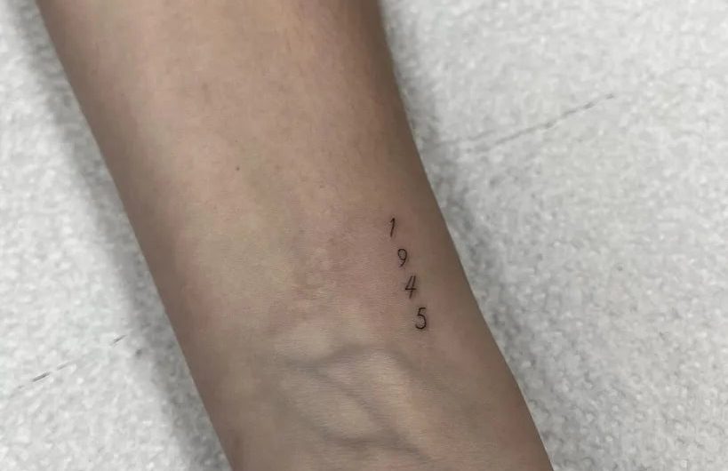 여성 손목에 새겨진 작고 미니멀한 숫자 문신