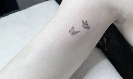 여성 팔에 새겨진 작고 미니멀한 두 마리 나비 문신