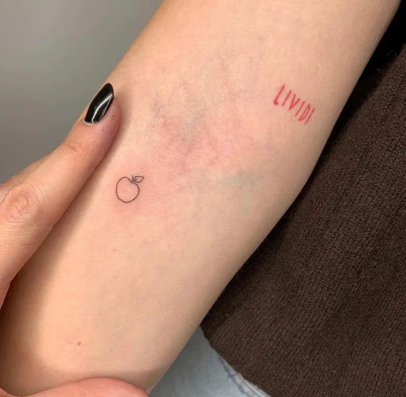 여성 팔에 새겨진 작고 미니멀한 애플 LIX 타투