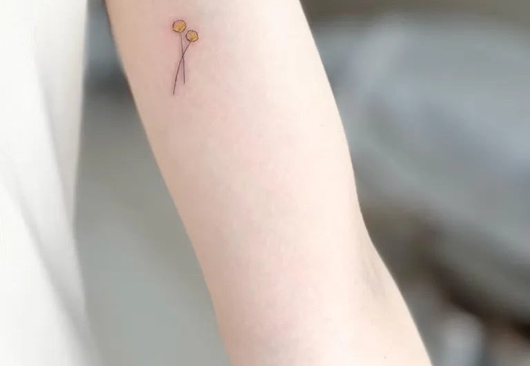 여성 팔에 있는 작고 미니멀한 풍선 두 개와 끈 문신