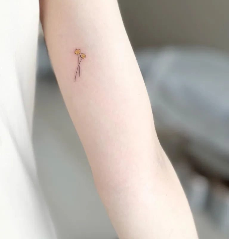 여성 팔에 있는 작고 미니멀한 풍선 두 개와 끈 문신
