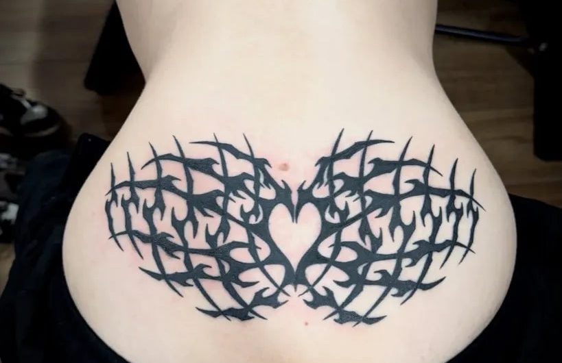 여성 허리 아랫부분에 새겨진 커다란 블랙워크 하트 문신