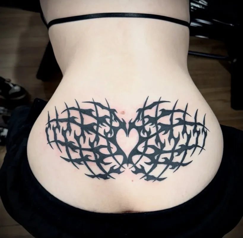 여성 허리 아랫부분에 새겨진 커다란 블랙워크 하트 문신
