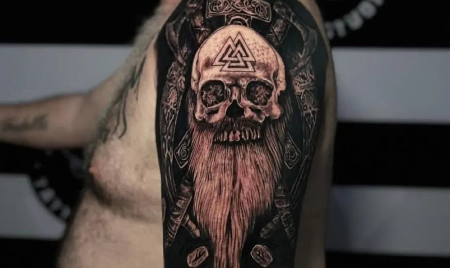 남성 팔뚝에 새겨진 크고 화려한 블랙워크 발크누트 해골 문신