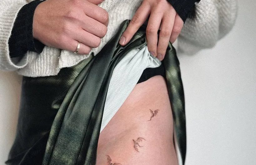 여성 엉덩이에 섬세한 라인으로 그린 ​​작은 새 문신
