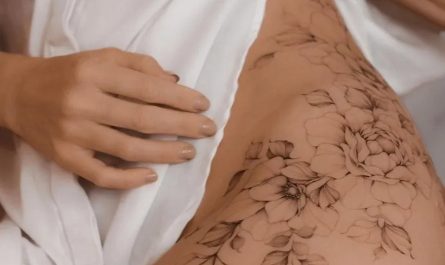 여성 엉덩이에 새겨진 중간 굵기의 가는 선으로 그린 ​​꽃 덩굴 문신