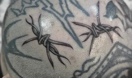남성 머리에 새겨진 크고 화려한 검은색 가시철사와 부족 문양 문신