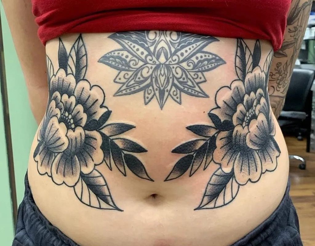 여성 복부에 새겨진 커다란 블랙워크 만다라 모란꽃 문신