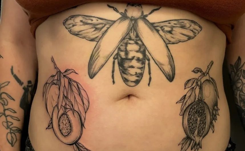 여성 복부에 새겨진 중간 크기 블랙워크 벌 아보카도 석류 문신