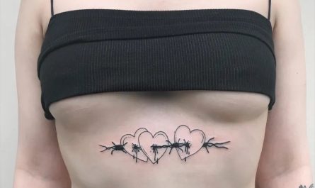 여성 복부에 새겨진 작고 섬세한 검은색 가시철사 하트 문신