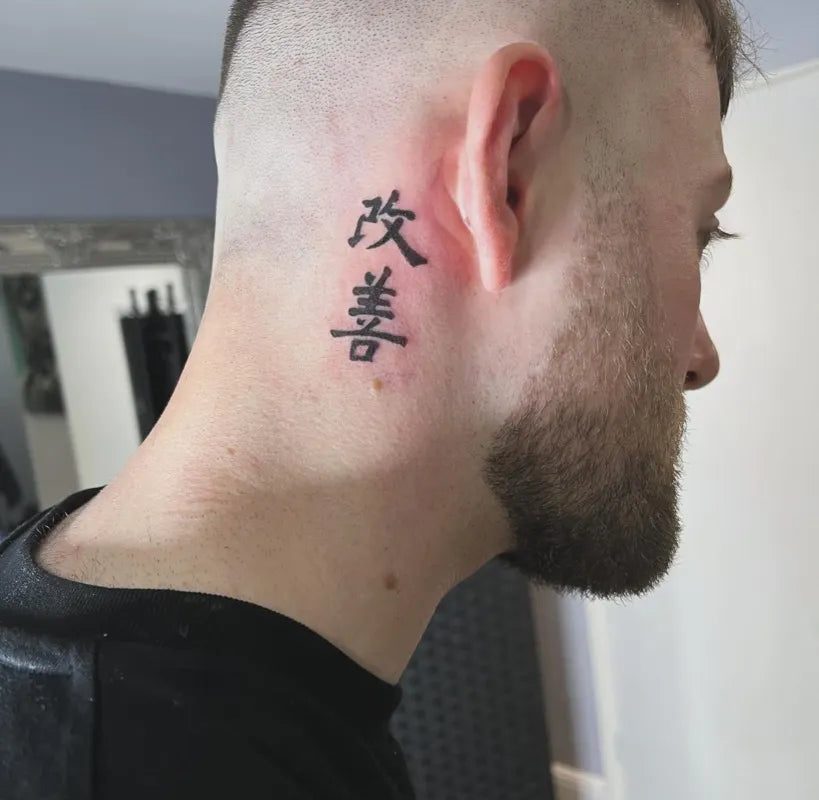 남성 귀 뒤에 새긴 작고 검은 '카이젠(Kaizen)' 한자 타투
