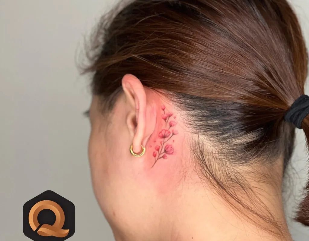 여성 귀 뒤에 새긴 작고 섬세한 꽃가지 라인워크 타투