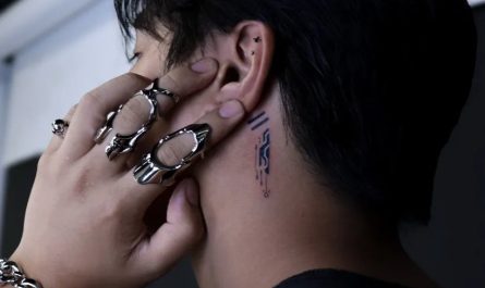 남성 귀 뒤편의 작은 블랙워크 라인워크 타투