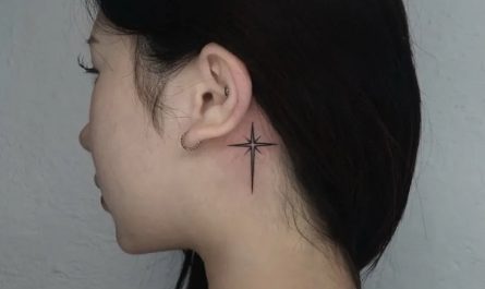 여성 귀 뒤에 새긴 작은 블랙워크 십자가 타투